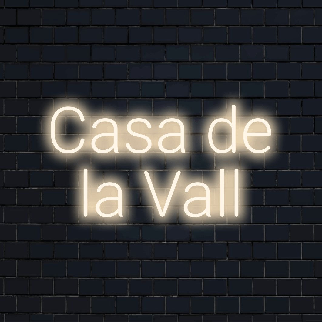 Casa De La Vall Neon Sign, bright neon glow on dark brick wall