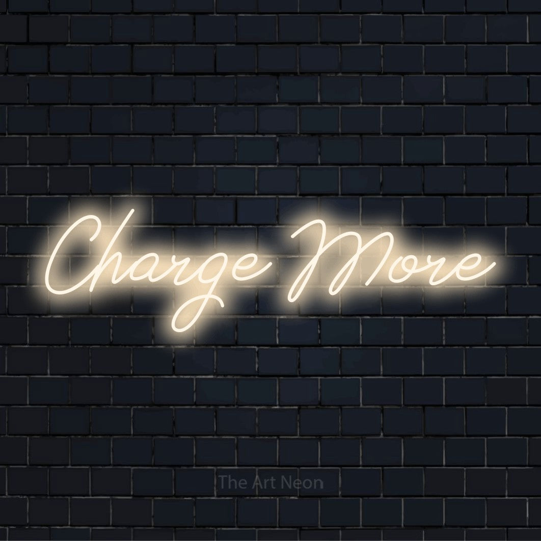 "Charge More" glowing LED neon sign on a black brick wall