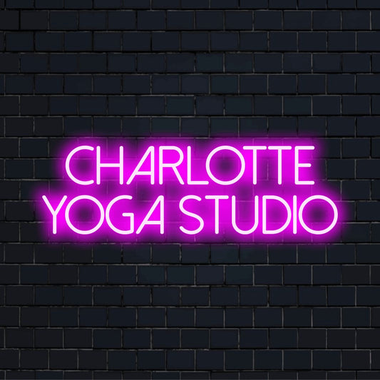 Charlotte Yoga Studio Personalized Neon Light with glowing lettering on black brick background