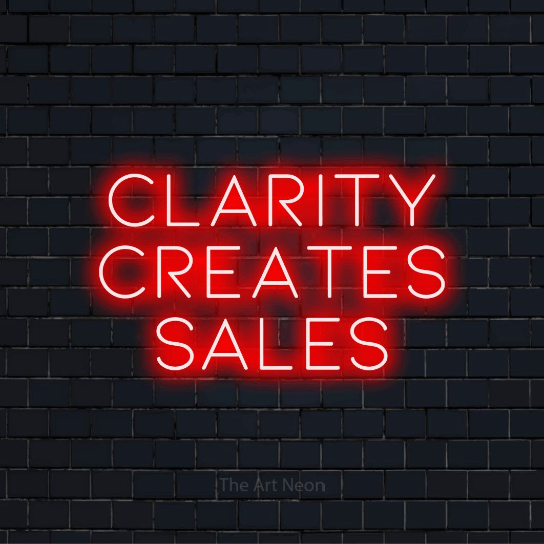 "Clarity Creates Sales" text design with neon effect on a black brick wall