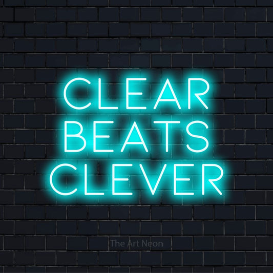 "Clear Beats Clever" text design with neon effect on a black brick wall