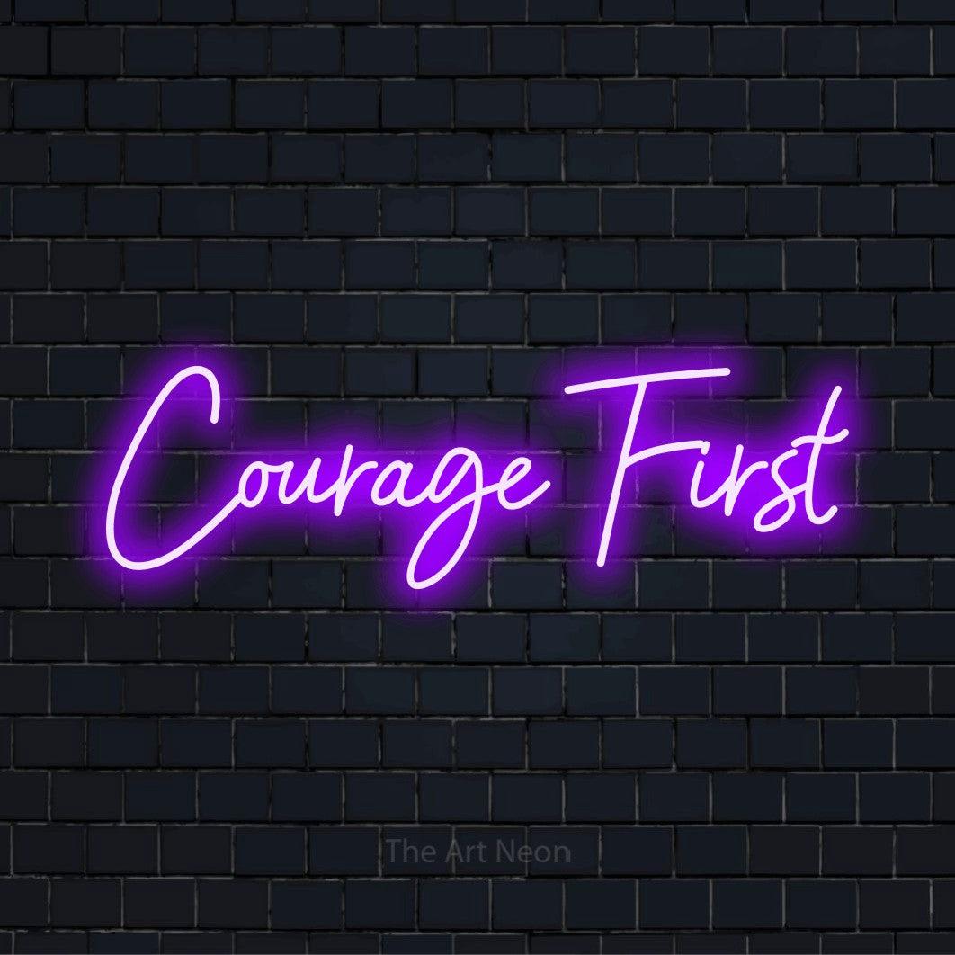 "Courage First" glowing LED neon sign on a black brick wall