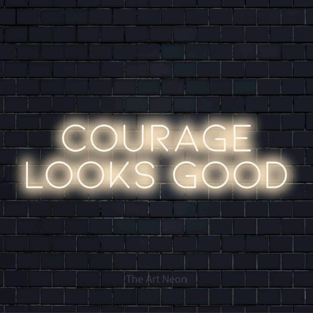 "Courage Looks Good" LED neon sign on a black brick wall