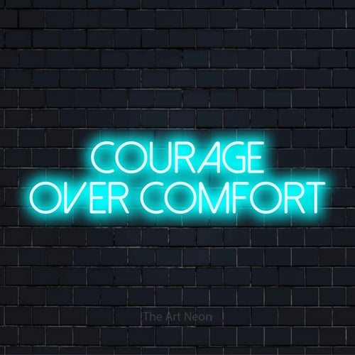"Courage Over Comfort" glowing LED neon sign on a black brick wall