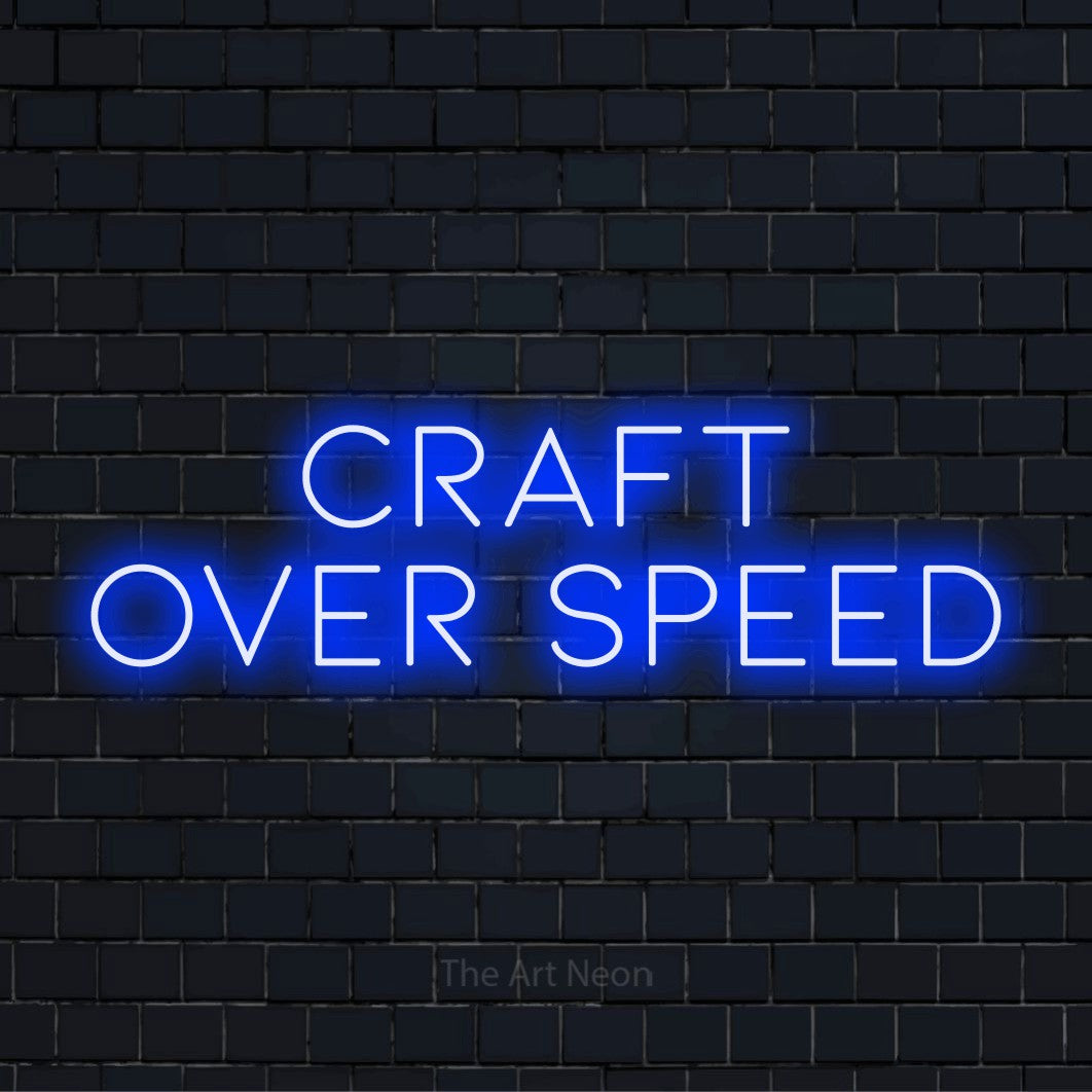 "Craft Over Speed" script-style LED neon sign on a black brick wall