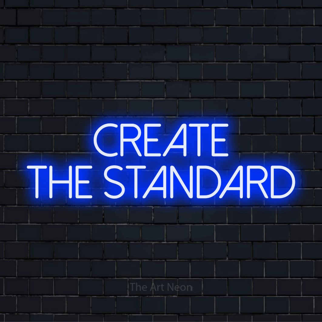 "Create The Standard" neon text design on a black brick wall