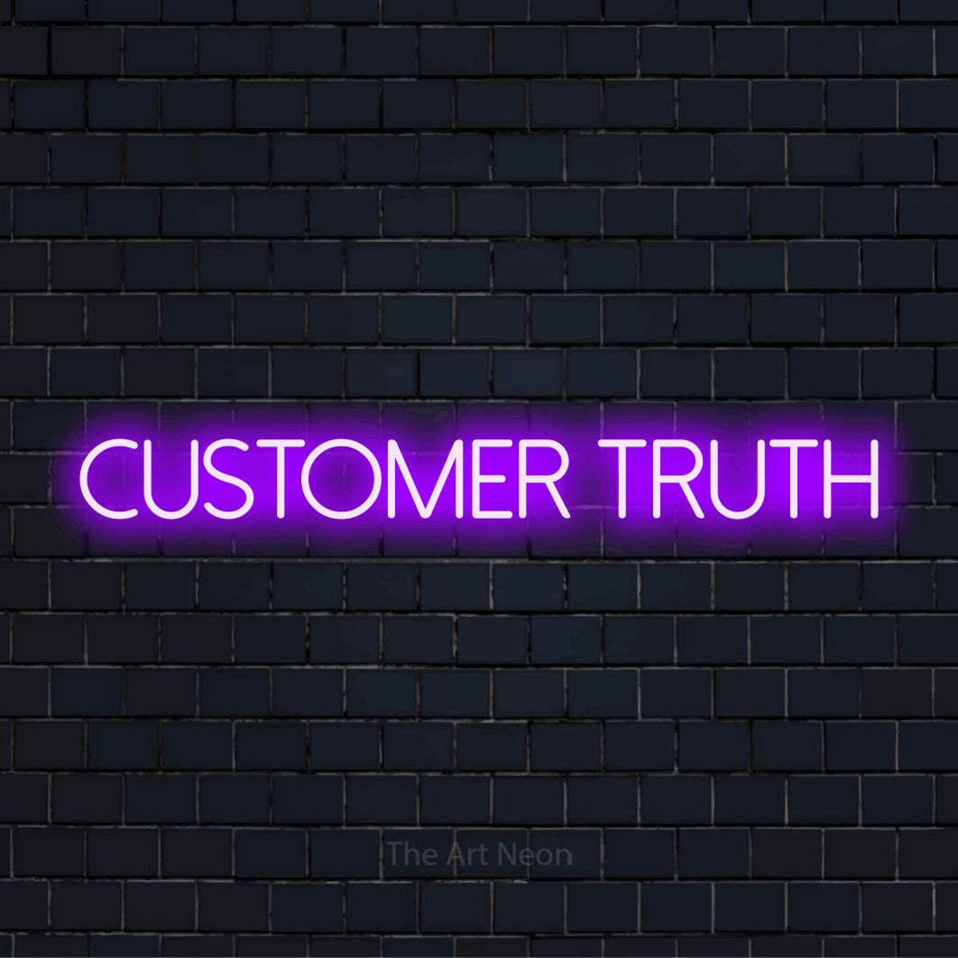 "Customer Truth" script-style LED neon sign on a black brick wall