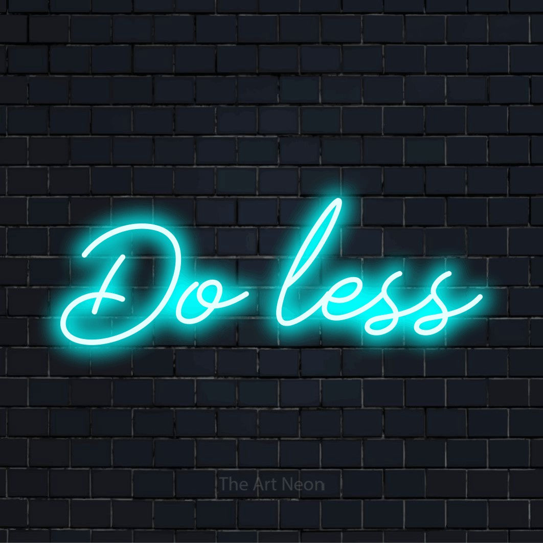 "Do Less" LED neon sign on a black brick wall