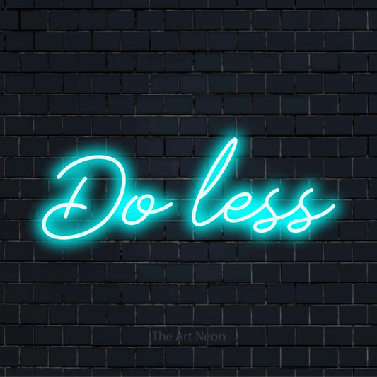 "Do Less" LED neon sign on a black brick wall