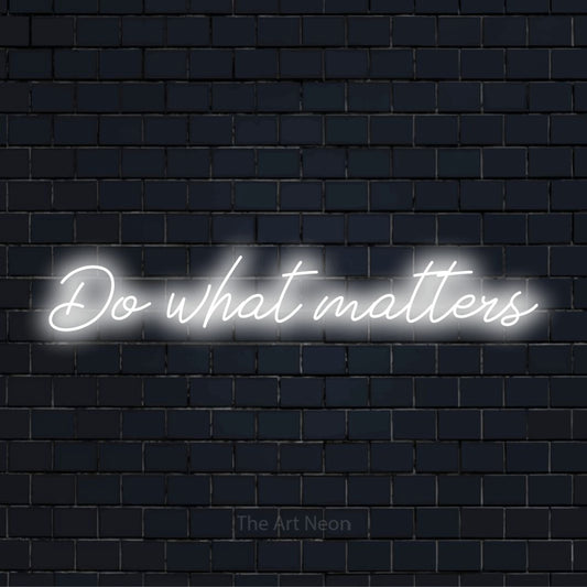 "Do What Matters" neon text design on a black brick wall