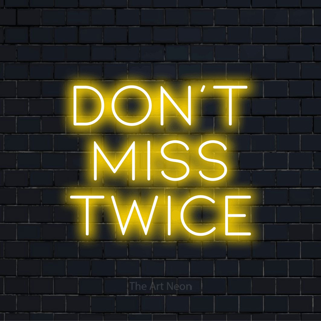 "Don’t Miss Twice" neon text design on a black brick wall