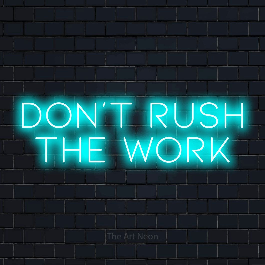 "Don’t Rush The Work" LED neon sign on a black brick wall