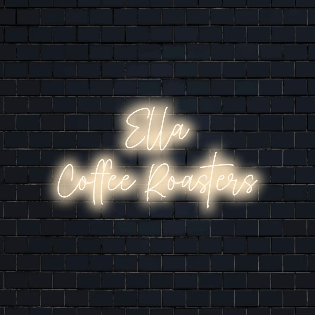 Ella Coffee Roasters Custom Name Neon Sign, bright neon lettering against black brick wall