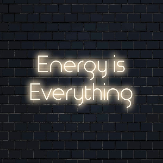 Energy Is Everything Neon Sign, neon text light against black brick wall