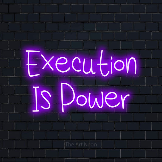 "Execution Is Power" script-style LED neon sign on a black brick wall