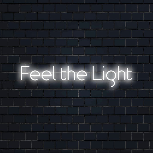 Feel The Light Neon Sign, glowing wall decor against brick backdrop