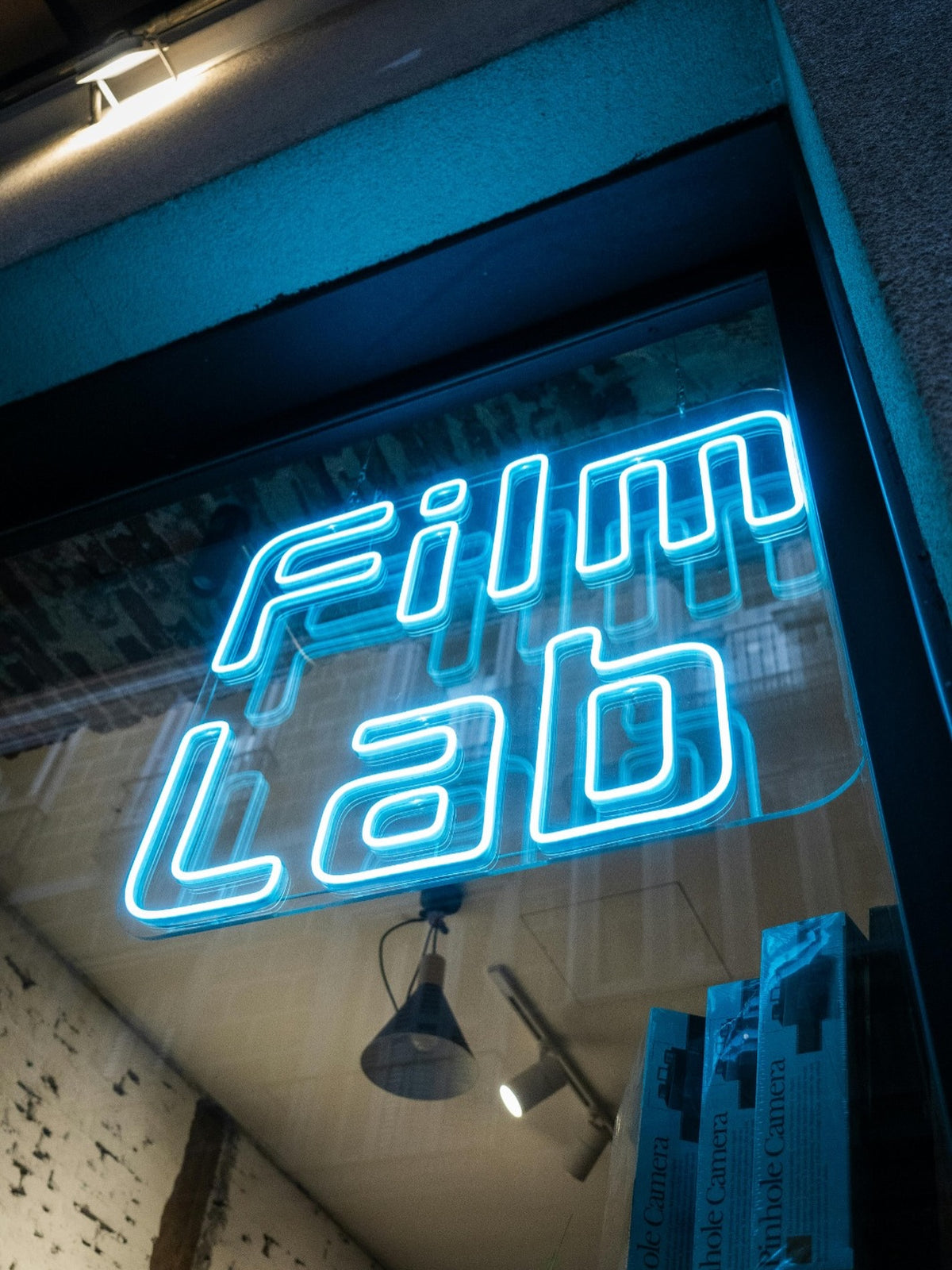 Blaues LED-Neonlogo von Film Lab innen in einem Schaufenster zur Straße