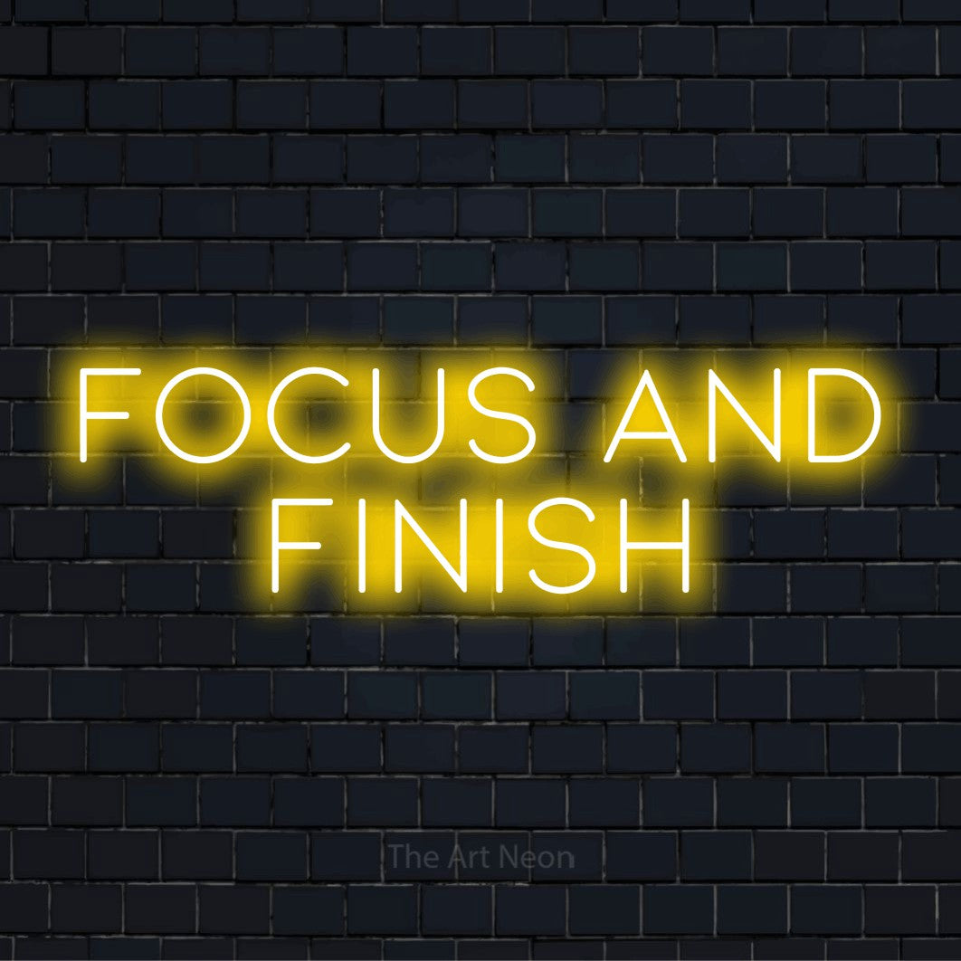 "Focus And Finish" LED neon sign on a black brick wall