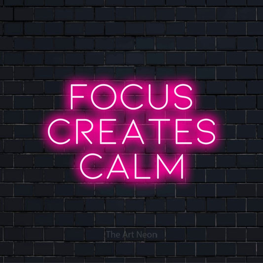 "Focus Creates Calm" text design with neon effect on a black brick wall