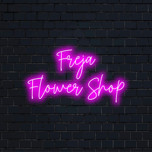 Freja Flower Shop Personalized LED Neon Sign, glowing lettering on dark brick background