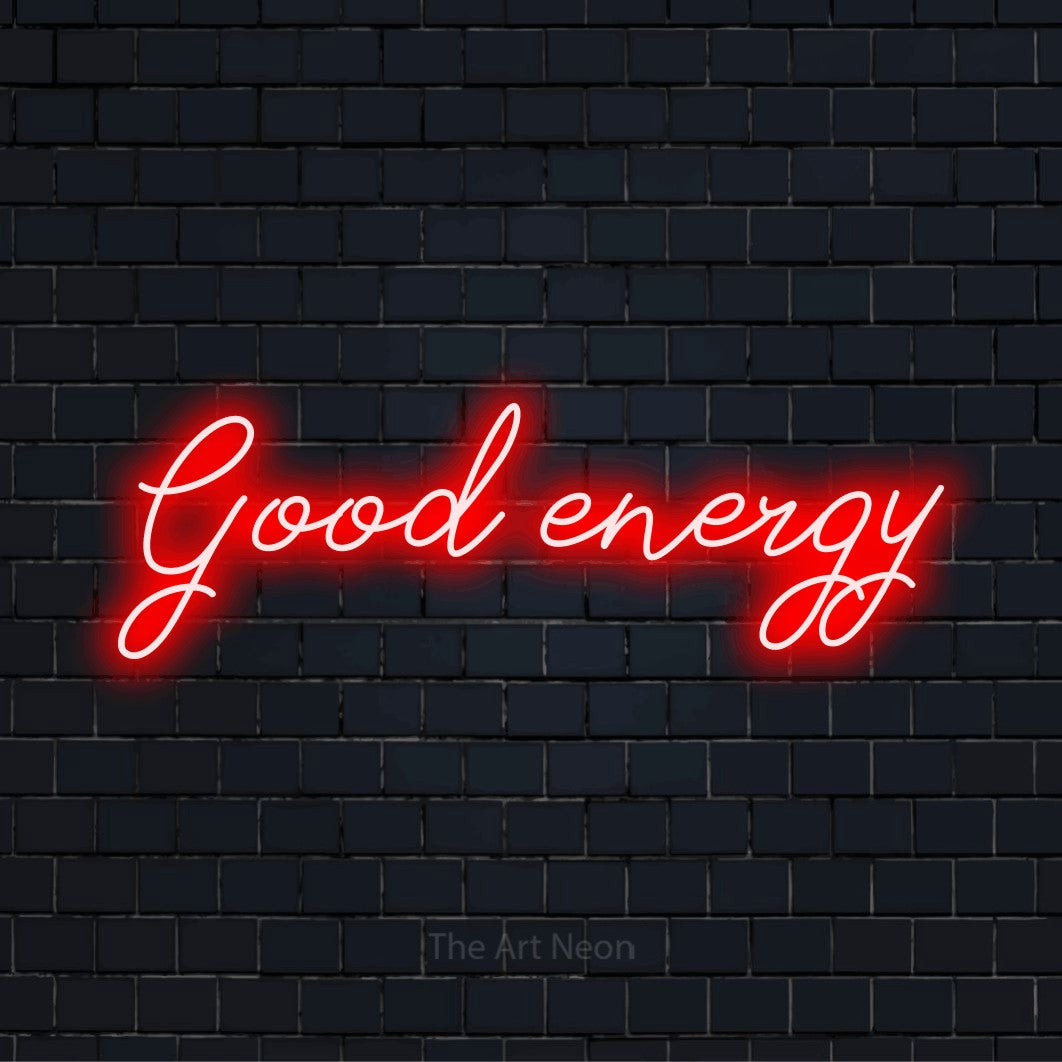 "Good Energy" script-style LED neon sign on a black brick wall
