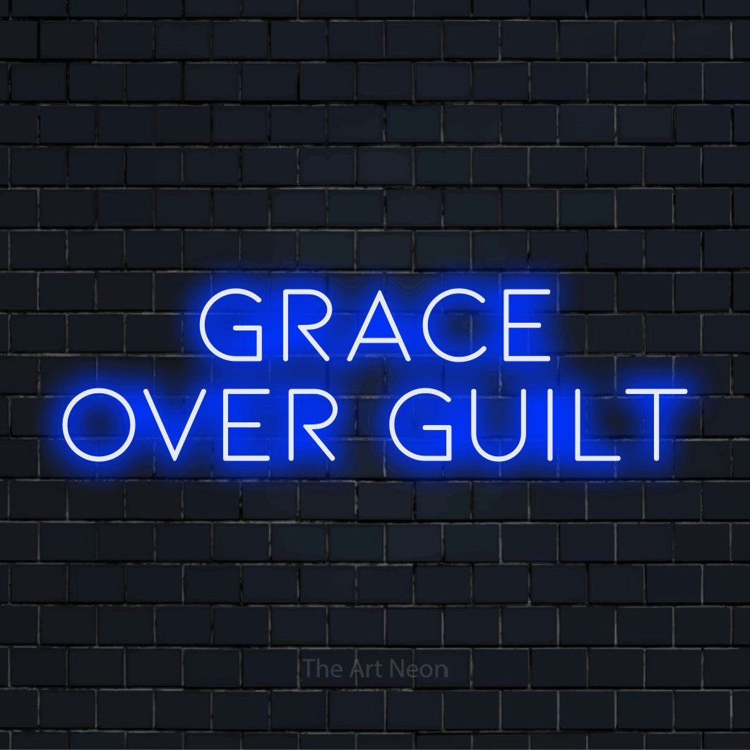 "Grace Over Guilt" neon text design on a black brick wall