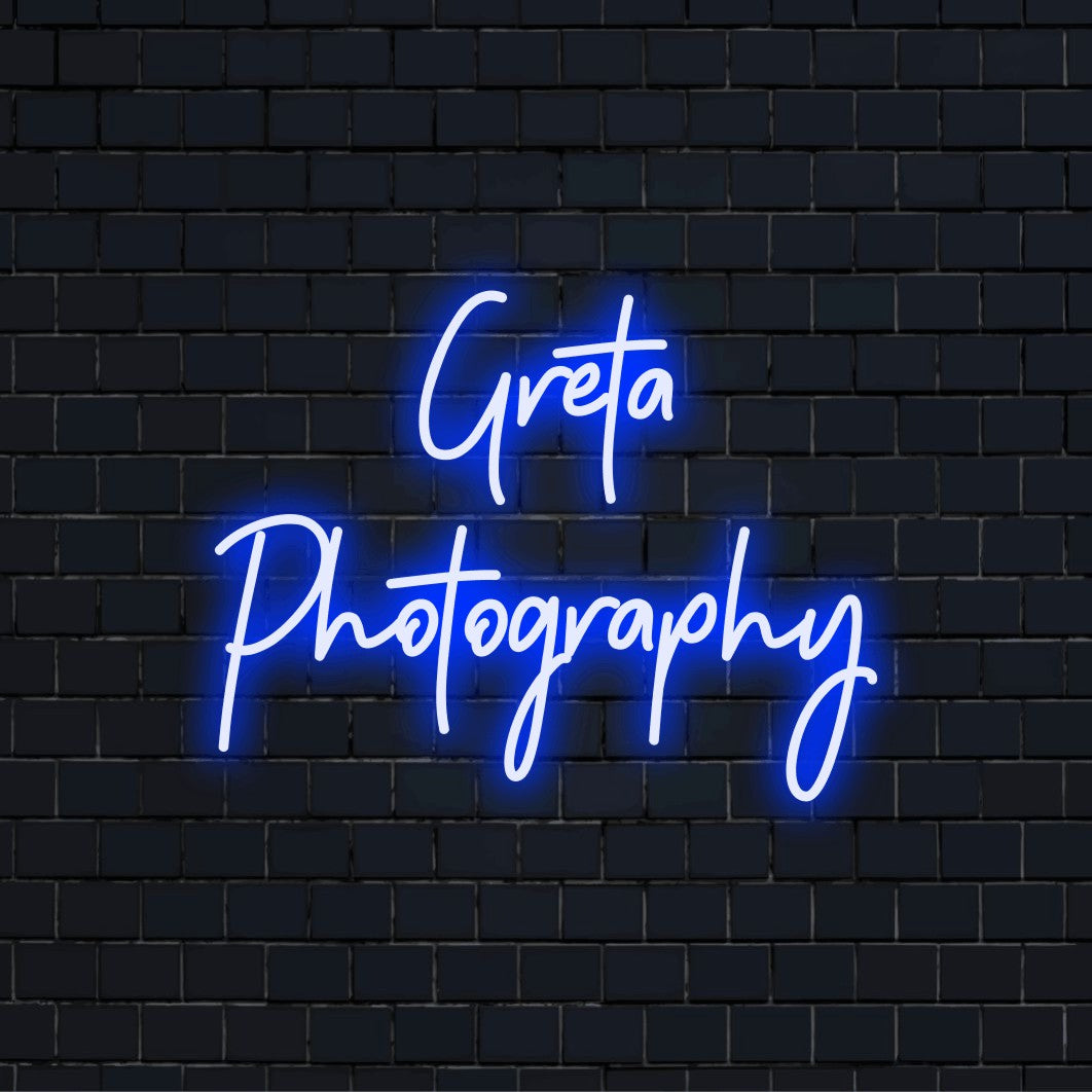 Greta Photography Custom Name Neon Sign, bright neon lettering on black brick background