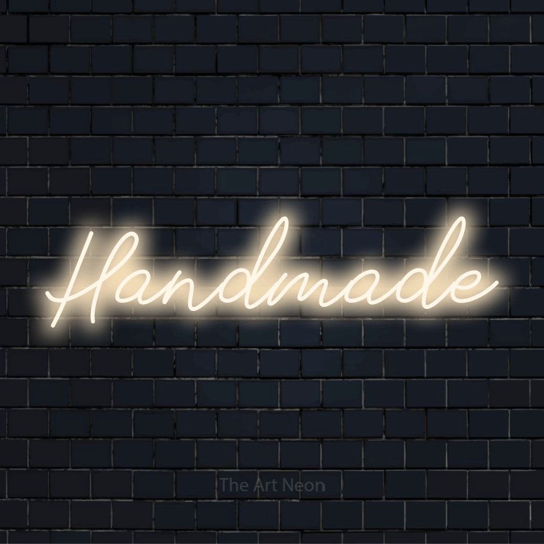 "Handmade" text design with neon effect on a black brick wall