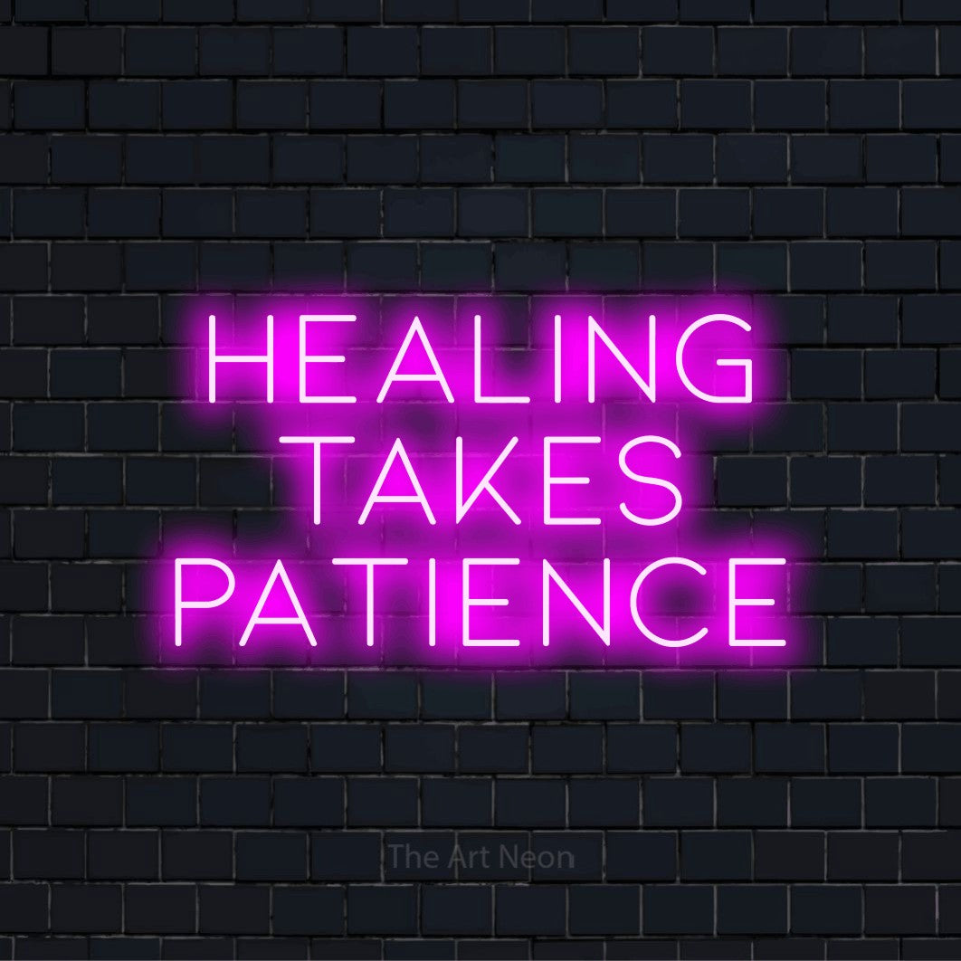 "Healing Takes Patience" text design with neon effect on a black brick wall