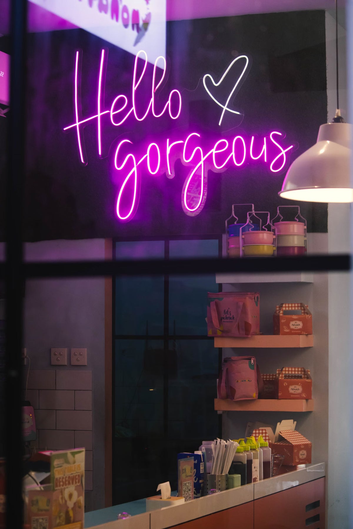 Rosa LED-Neonschild „Hello Gorgeous“ hinter dem Schaufenster eines Einzelhandelsgeschäfts