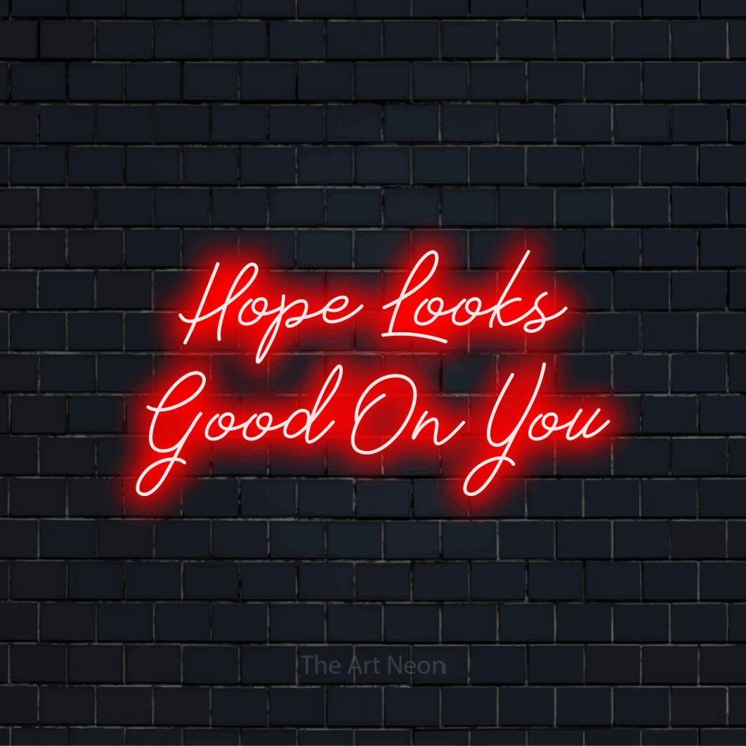 "Hope Looks Good On You" script-style LED neon sign on a black brick wall