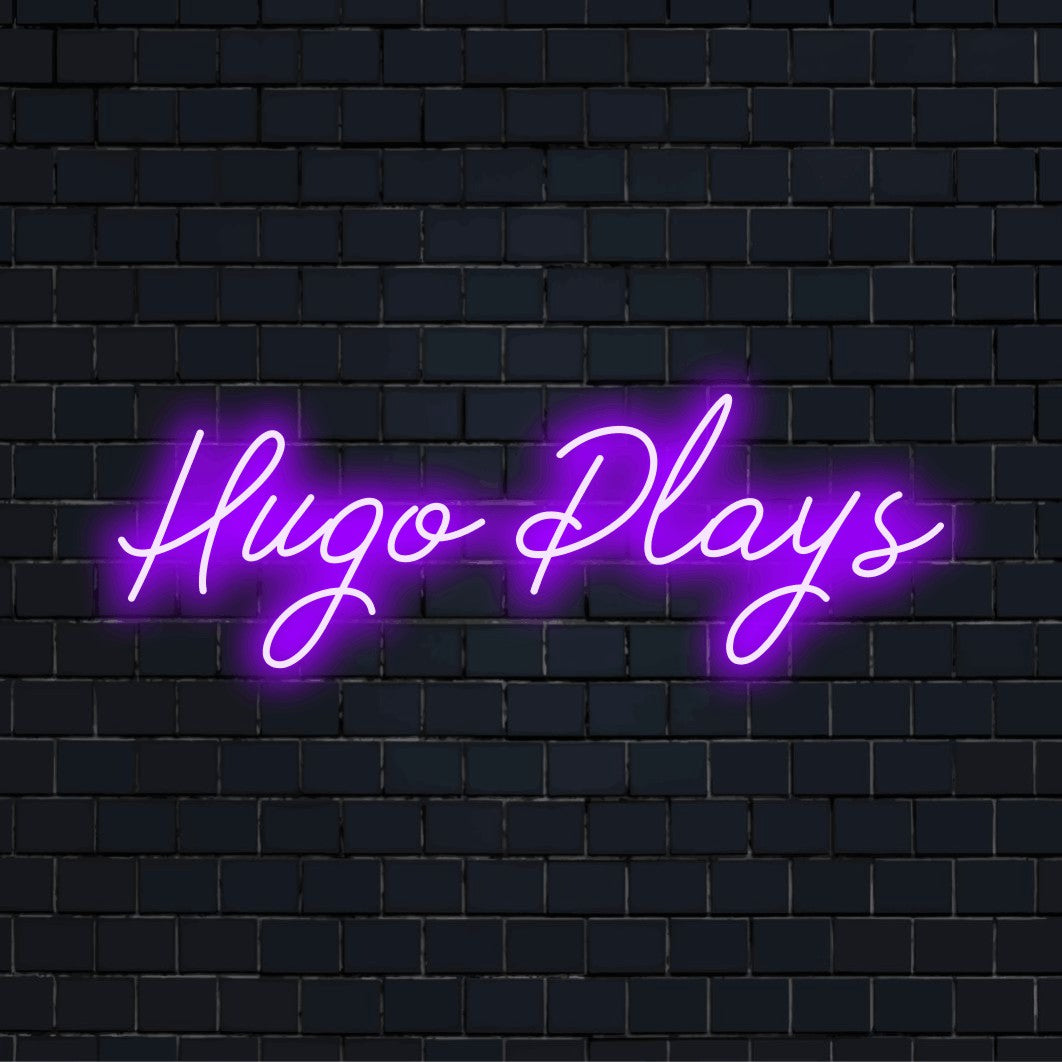 Hugo Plays Custom Name Neon Sign, bright LED glow against black brick wall