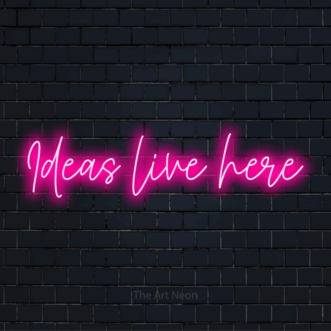 "Ideas Live Here" neon text design on a black brick wall