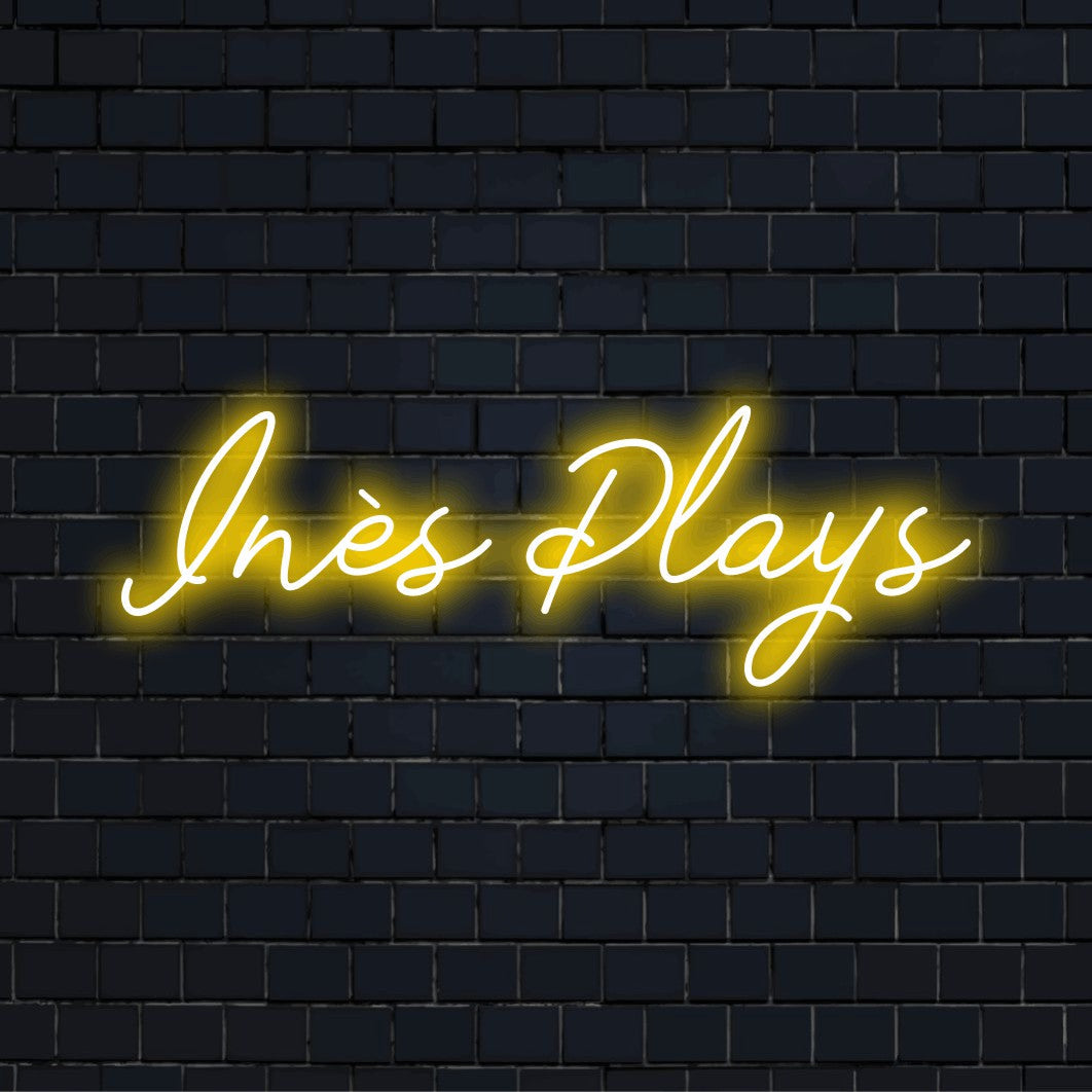 Ines Plays Personalized LED Neon Sign, glowing neon text on dark brick wall