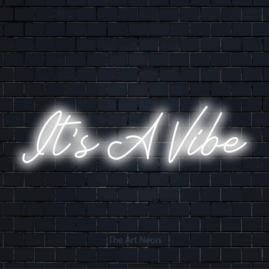 "It’s A Vibe" neon text design on a black brick wall