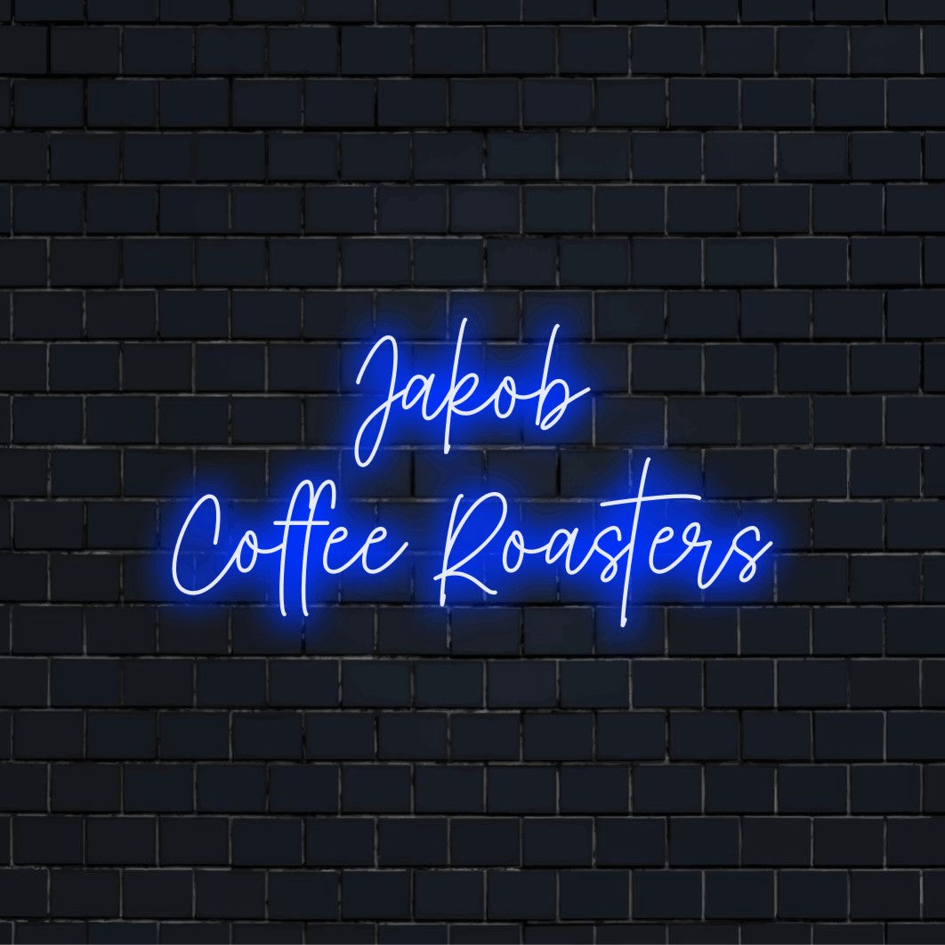 Jakob Coffee Roasters Personalized Neon Light with soft neon glow against brick backdrop