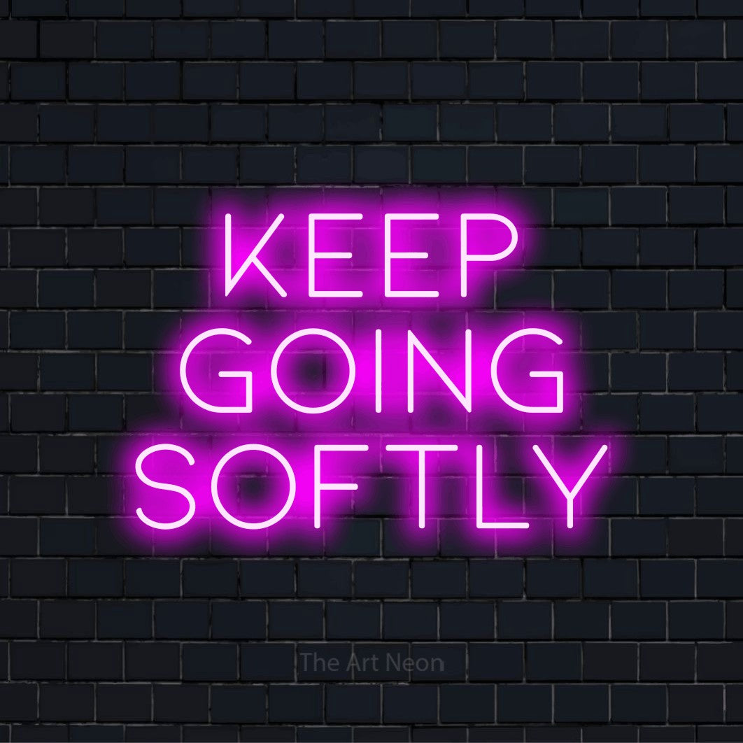 "Keep Going Softly" LED neon sign on a black brick wall