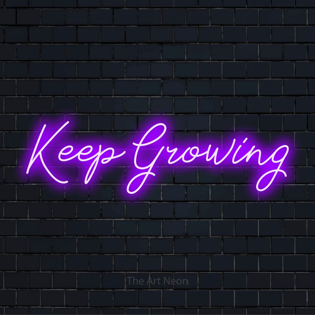 "Keep Growing" glowing LED neon sign on a black brick wall