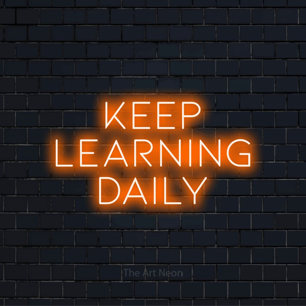"Keep Learning Daily" glowing LED neon sign on a black brick wall