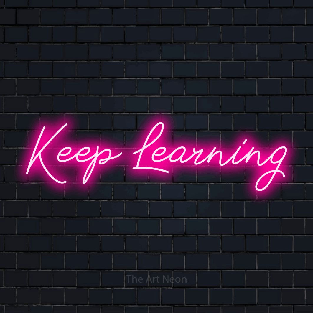"Keep Learning" glowing LED neon sign on a black brick wall