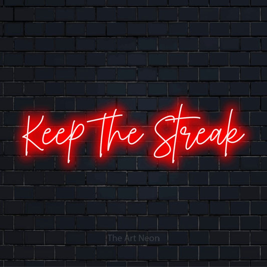 "Keep The Streak" glowing LED neon sign on a black brick wall