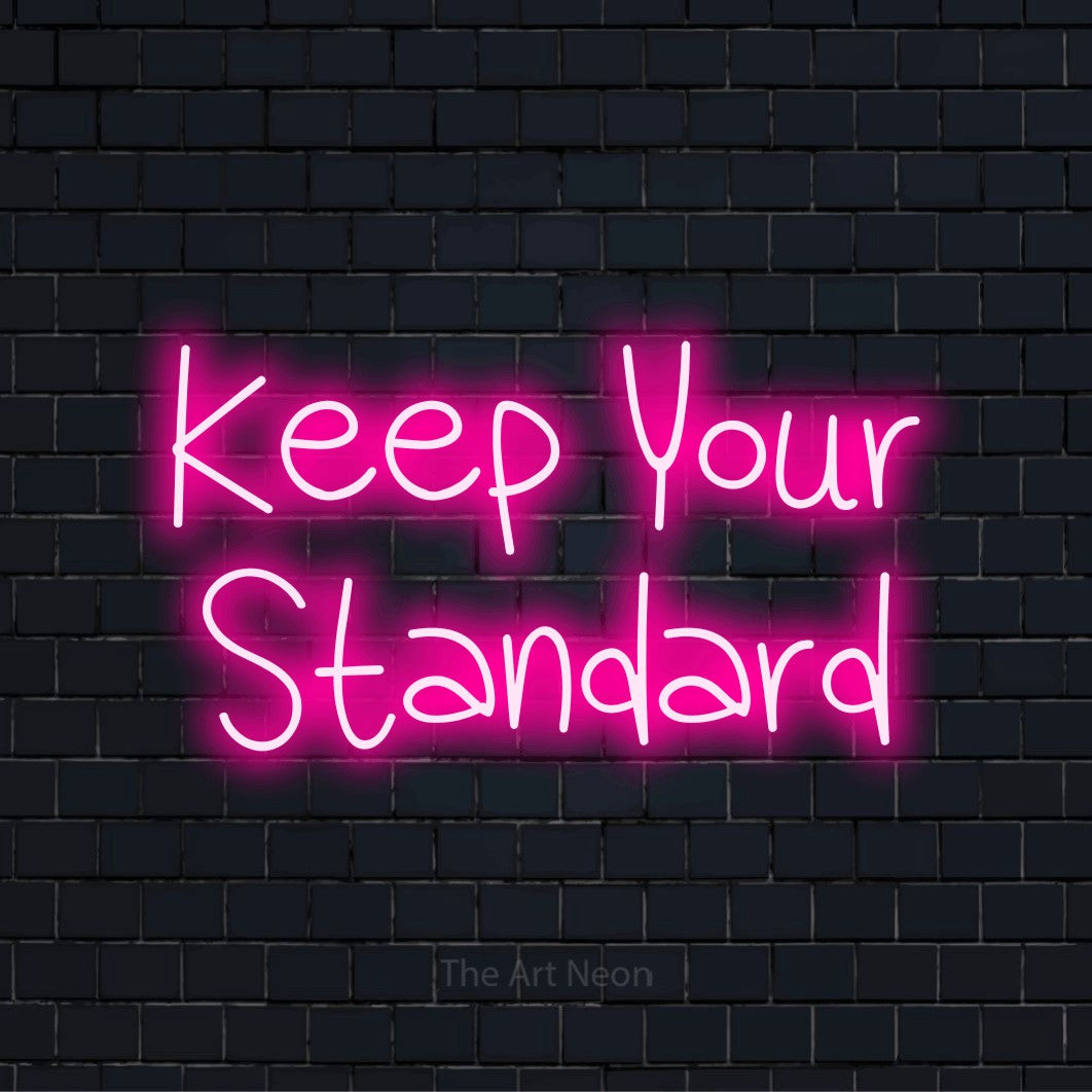 "Keep Your Standard" glowing LED neon sign on a black brick wall