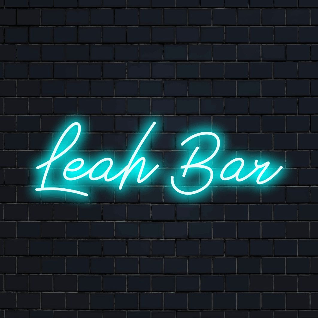 Leah Bar Custom Name Neon Sign, neon text light against black brick wall