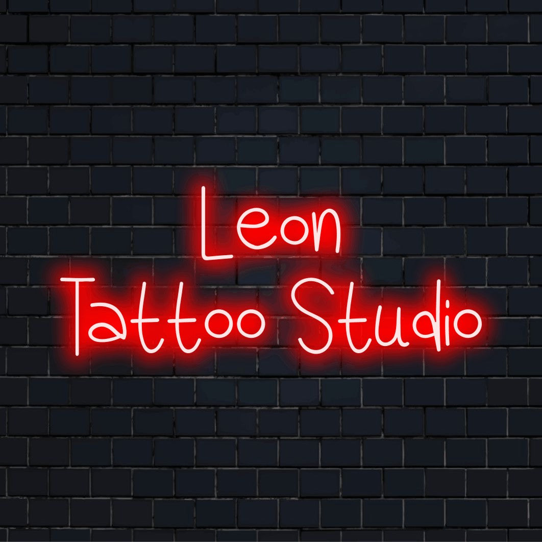 Leon Tattoo Studio Custom Name Neon Sign, soft neon glow on black brick background