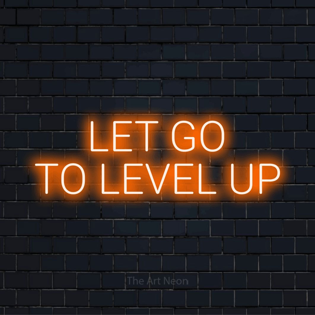 "Let Go To Level Up" glowing LED neon sign on a black brick wall
