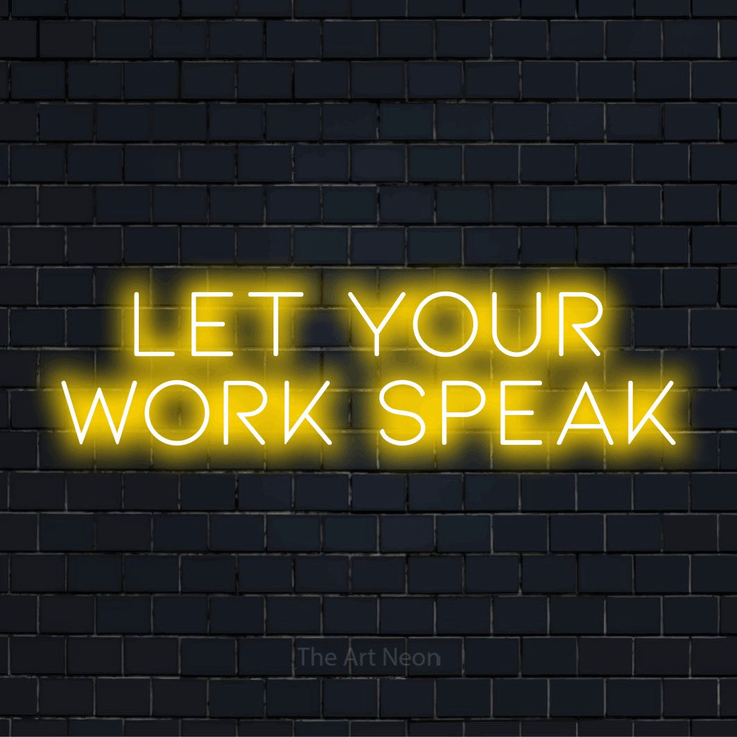 "Let Your Work Speak" script-style LED neon sign on a black brick wall