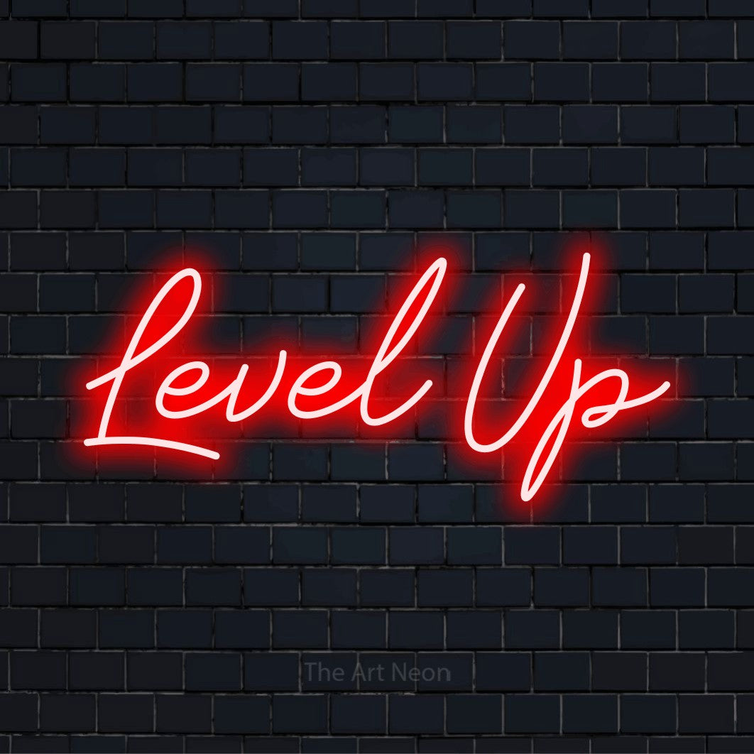 "Level Up" script-style LED neon sign on a black brick wall