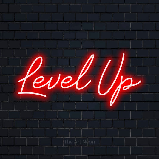 "Level Up" script-style LED neon sign on a black brick wall