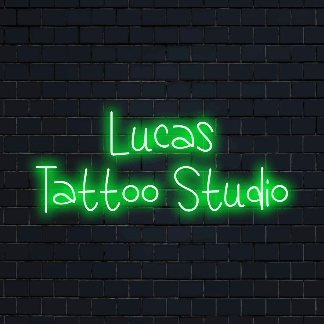 Lucas Tattoo Studio Custom Name Neon Sign, glowing wall decor on dark brick wall
