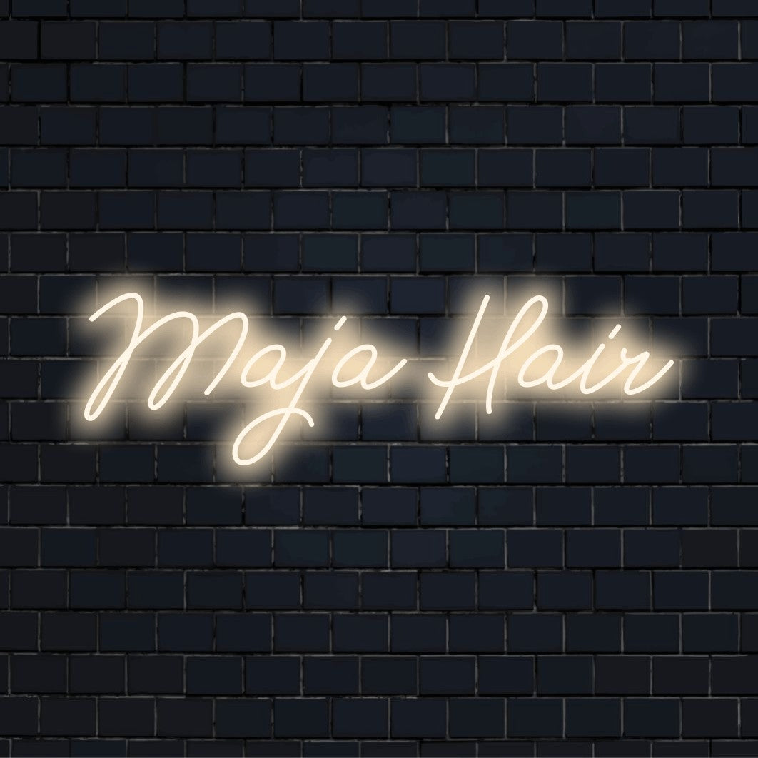Maja Hair Custom Name Neon Sign, glowing lettering against black brick wall